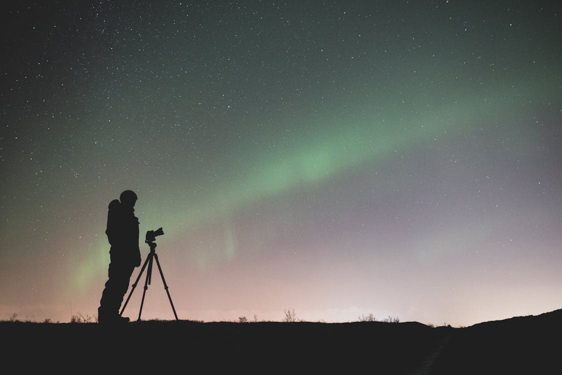 Person photographing the night sky with a smartphone