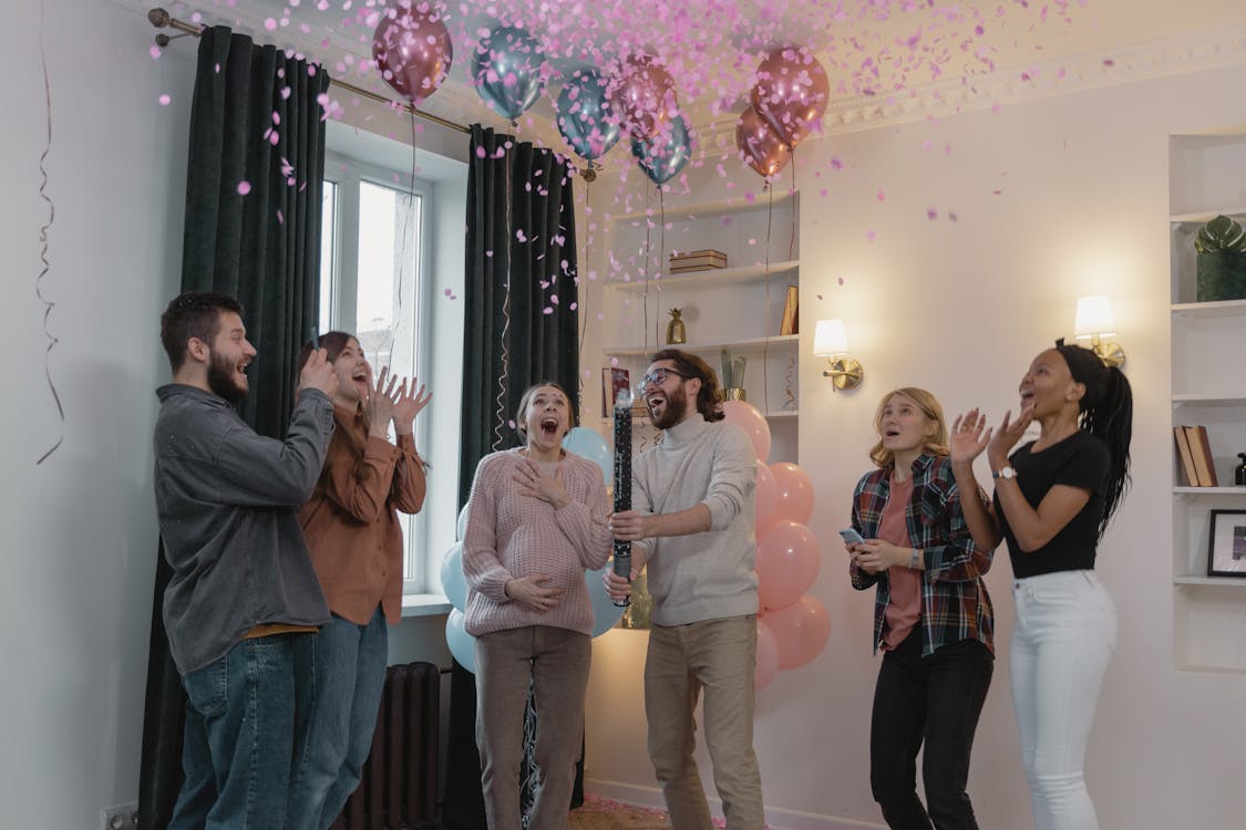 Happy people celebrating with pink confetti in the air